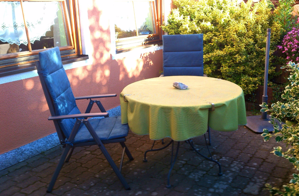 Gartentisch mit blauen Liegestühlen
